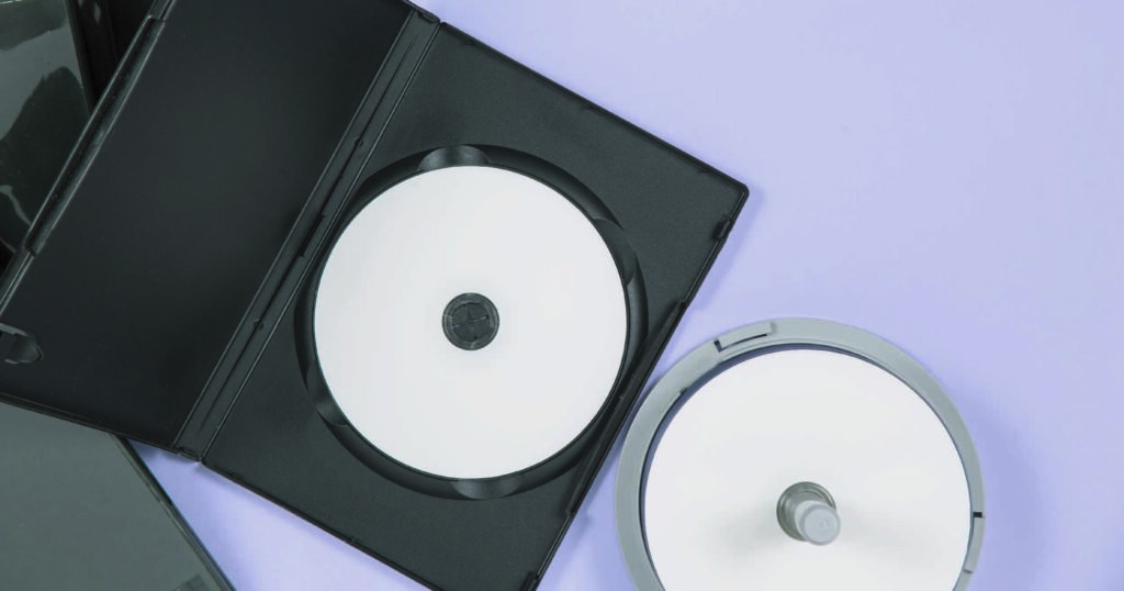 CD's en una caja negra sobre fondo violeta